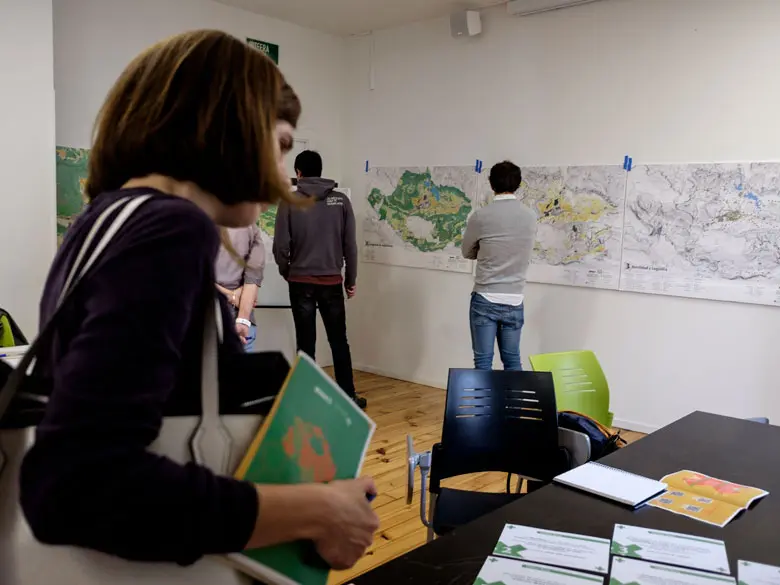 Una participante mirando la información facilitada para promover la elección de la mesa temática sobre la que cada persona va a trabajar